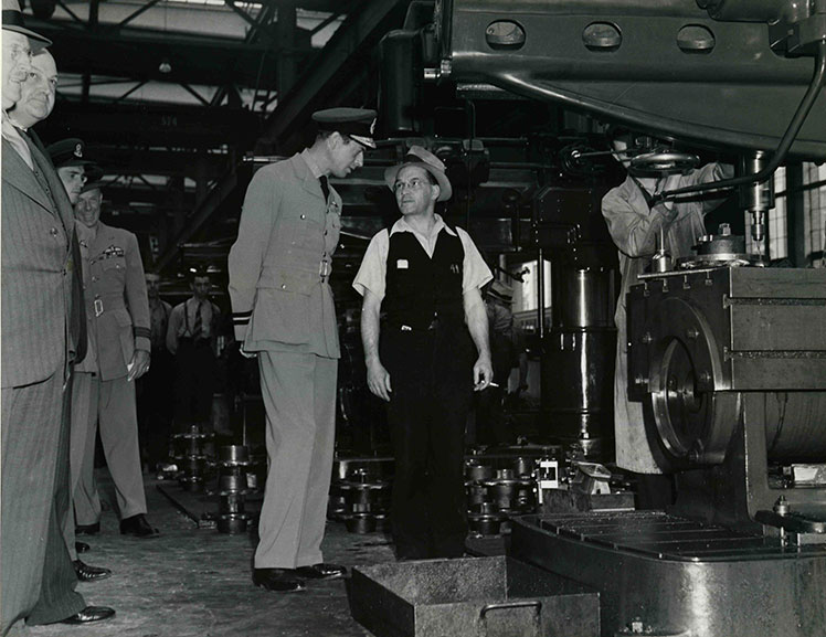 Un homme en uniforme s'adressant à un ouvrier dans l'usine.