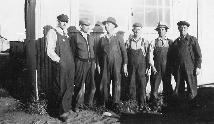 Six hommes devant une bâtisse