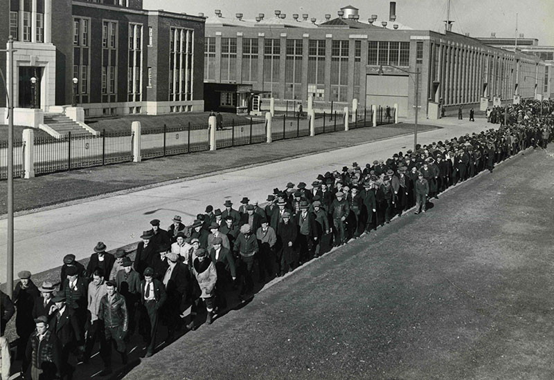 Un grand nombre de travailleurs sortent de l'usine.