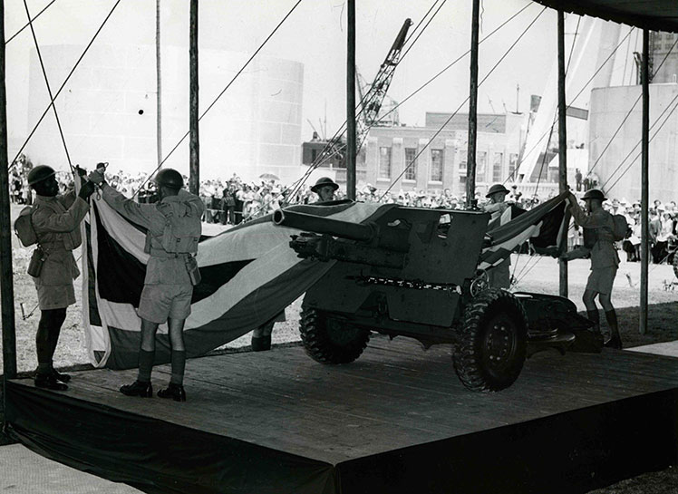 Des soldats enlèvent le drapeau qui était sur le canon.